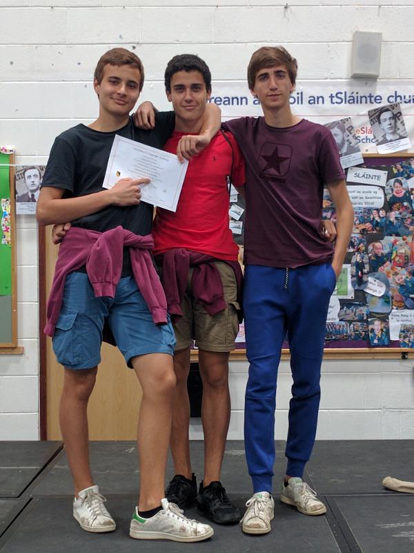 trois jeunes montrent leur diplôme et posent pour la photo