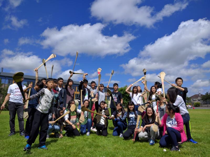 un groupe de jeunes tenant des crosses de jeu pendant leur séjour linguistique Irlande famille d'accueil