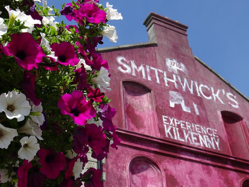 Façade d'un bâtiment rose avec des fleurs