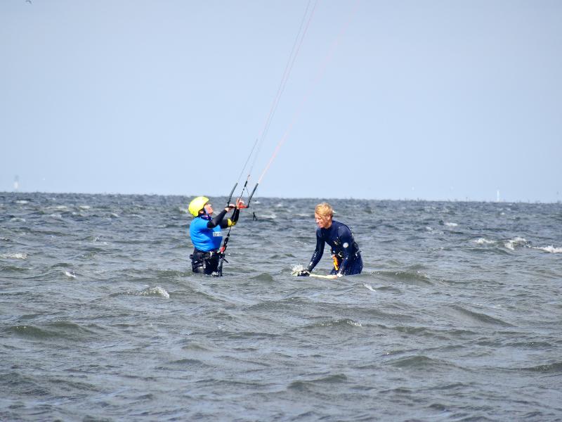 deux jeunes dans l'eau avec une board