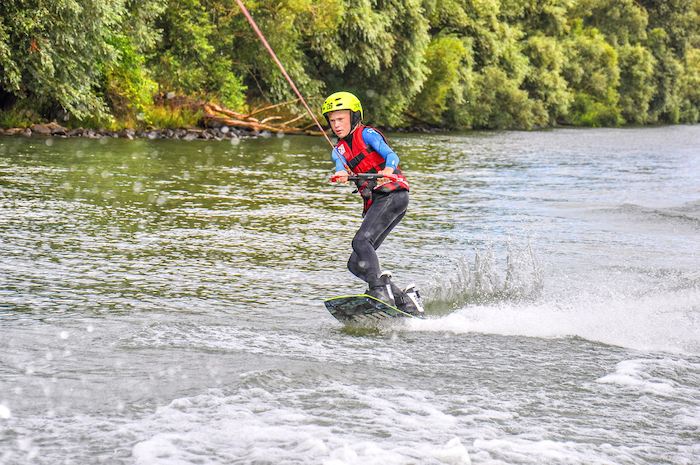 jeune sur l'eau sur une planche en colo wakeboard
