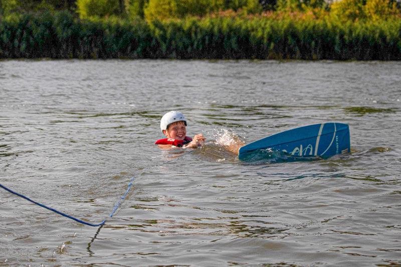 garçon dans l'eau avec son casque en colonie de vacances wakeboard