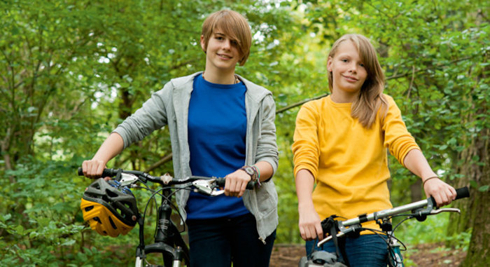 Jeunes filles sourient à la caméra sur leurs vélos en séjour linguistique allemand