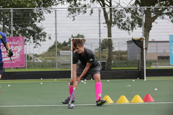 Un jeune s'entraine en colo hockey 