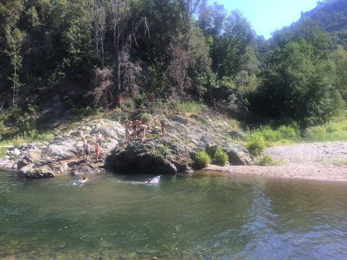 Les ado sautent dans la rivière lors d'une colonie de vacances corse