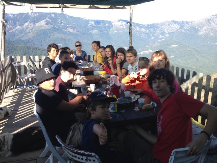 Le groupe d'ado mange au milieu des montagnes lors d'une colonie de vacances corse