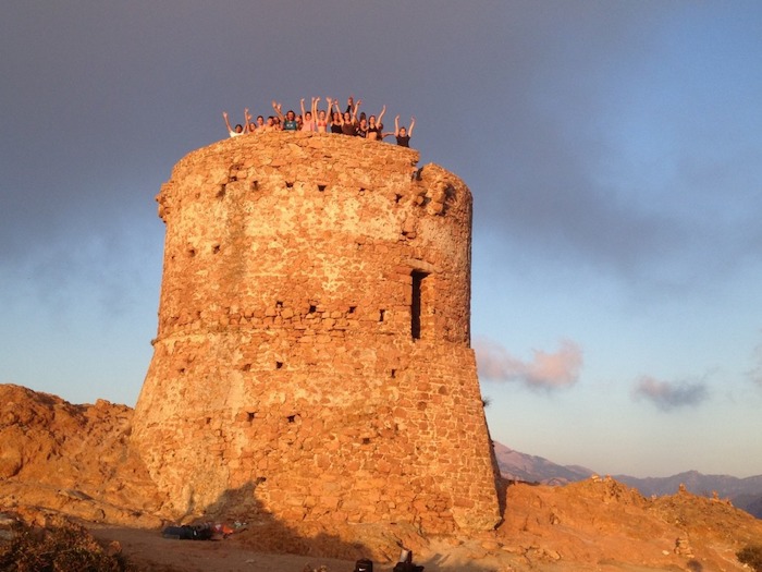 Les participants sont en haut de la tour génoise ensoleillée lors d'un séjour itinérant en Corse