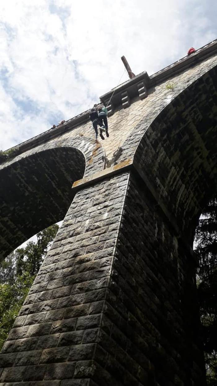 Deux jeunes descendent en rappel sous un pont lors d'une colonie de vacances bretagne