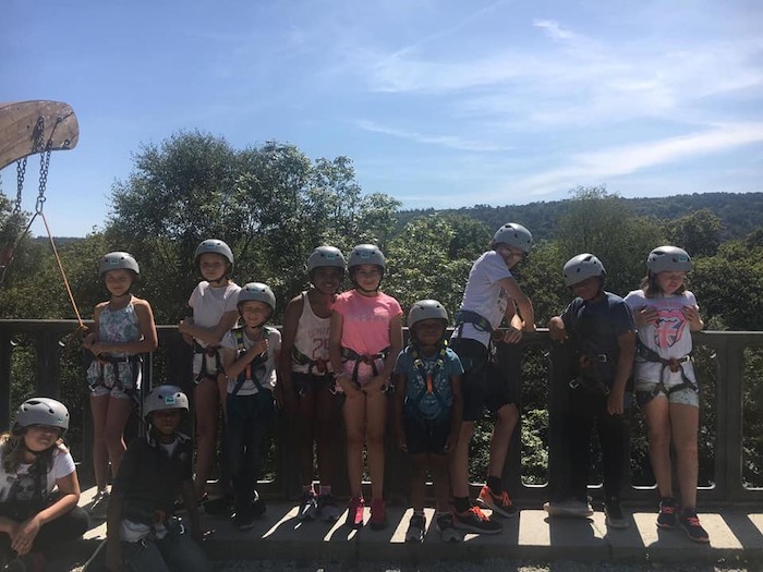 Les jeunes sont alignés sur le pont avec leur casques avant las descente en rappel lors d'une colonie de vacances bretagne