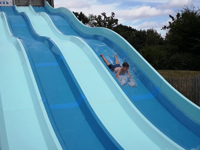Un ado descend du toboggan sur le ventre lors d'une colonie de vacances bretagne