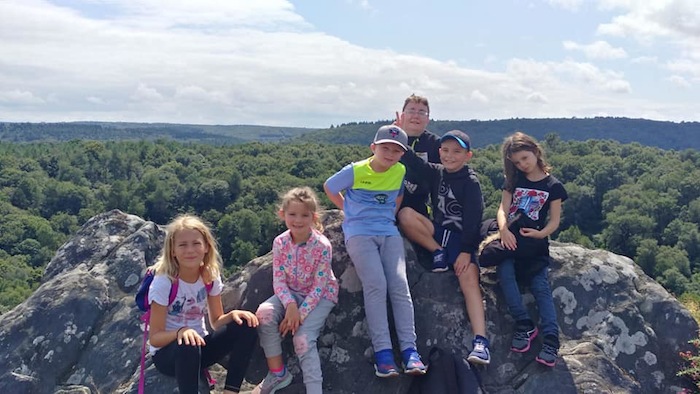 Les enfants sont assis sur les roches après la randonnée lors d'une colonie de vacances en Bretagne