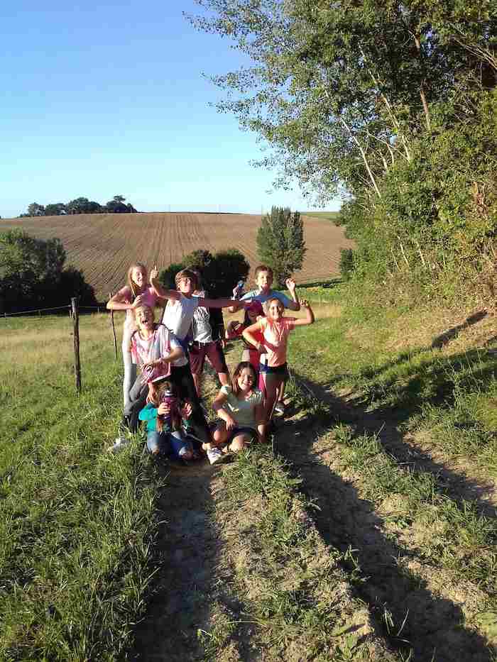 Des enfants en colonie de vacances en pleine nature prennent la pose