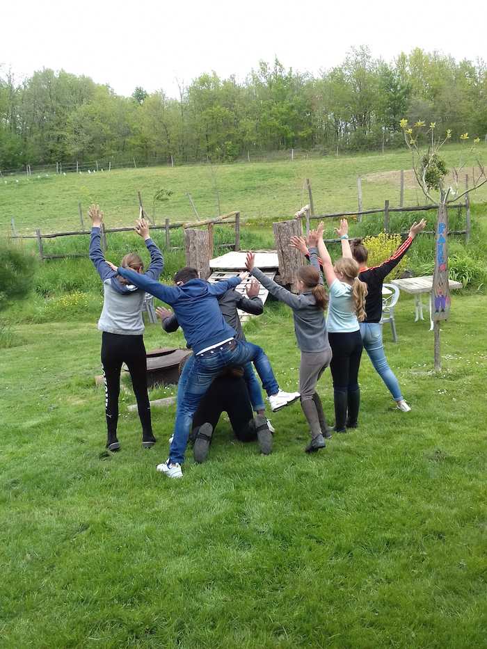 Groupe de jeunes s'amusent dehors pendant une colonie de vacances équitation