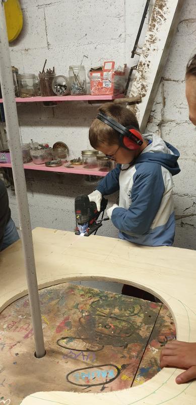 Enfant faisant du ponçage pendant une colonie de vacances bricolage