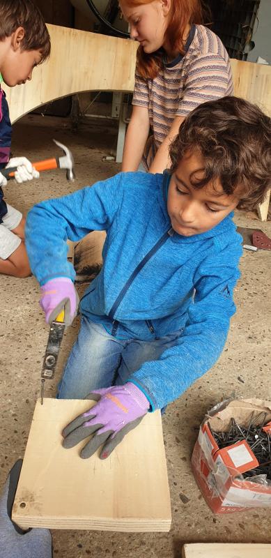 Un enfant utilisant une truelle pendant une colonie de vacances bricolage