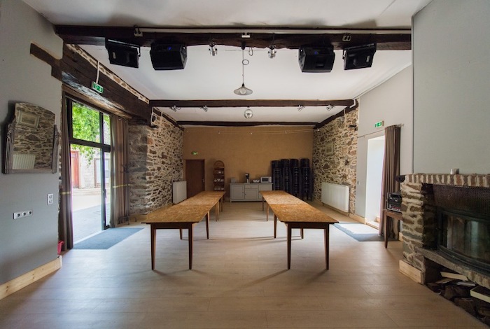 Salle à manger de la colonie de vacances avec deux longues tables et une cheminée