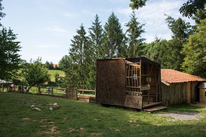Photo d'une cabane de la colonie de vacances à la ferme avec le parc et les arbres