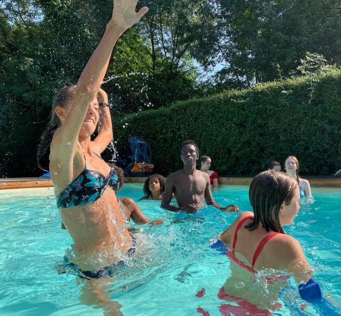 Une jeune fille saute dans la piscine de la colonie de vacances