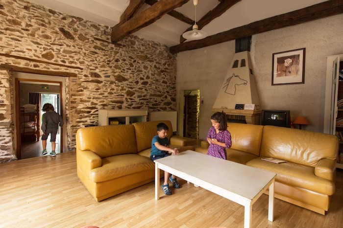 Salle de repos avec poutre apparente et mûrs avec pierre en colonie de vacances