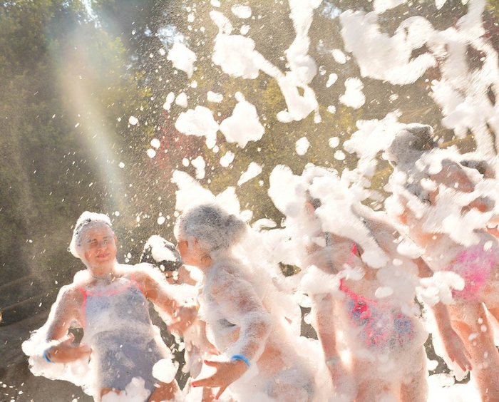 Des participants à une colonie de vacances multisport s'amusent dans la mousse