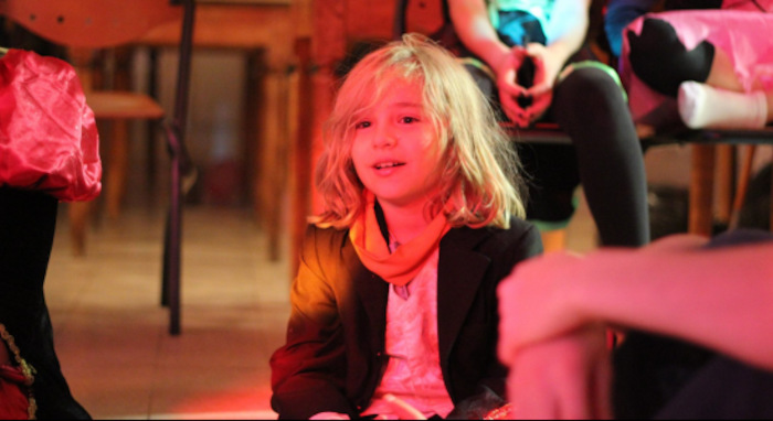 Enfant qui regarde un spectacle de cirque lors d'une colo artistique