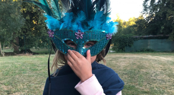 Fille déguisée avec un masque bleu lors d'une colonie de vacance artistique