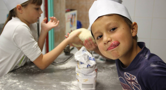 enfant préparant une recette lors d'une colonie artistique