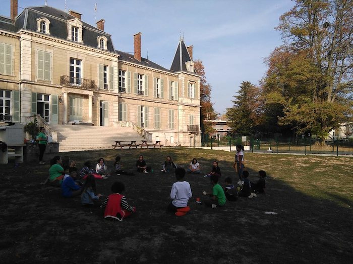 groupe de jeunes assis sur le parvis du château de la colonie de vacances