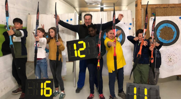 Les enfants sont alignés et tirent à l'arc
