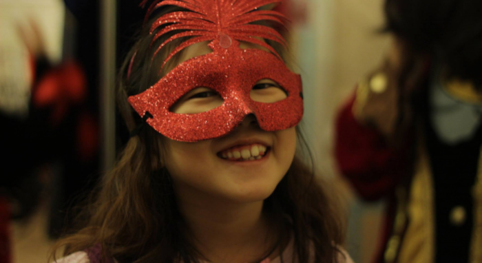 Une fille est déguisée d'un masque rouge lors d'une colonie de vacances artistique