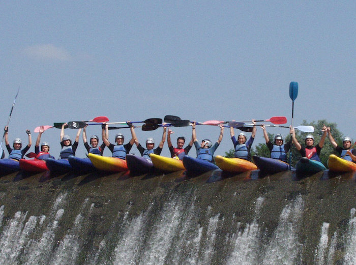 Jeunes alignés avec des kayaks au dessus de la rivière lors d'une colonie de vacances en Hautes-Pyrénées