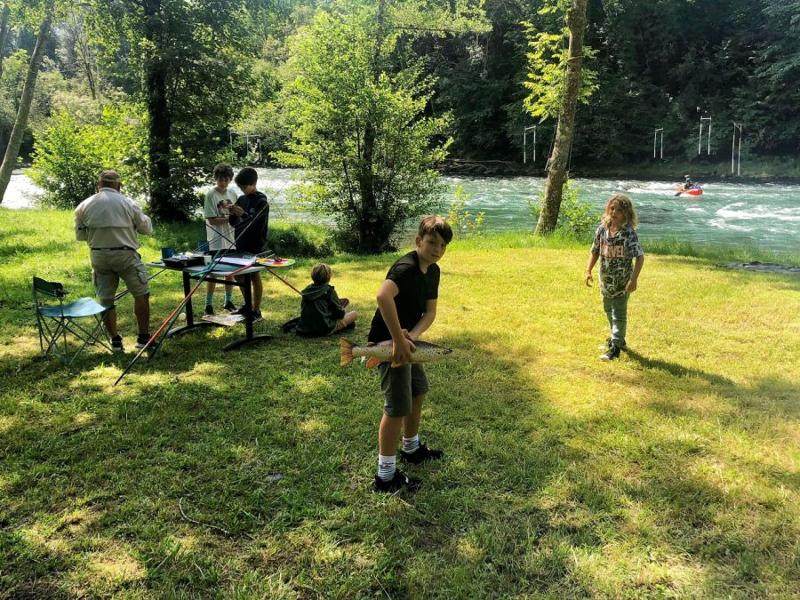 Des enfants jouent avec un poisson dans un jardin pendant une colonie Hautes-Pyér