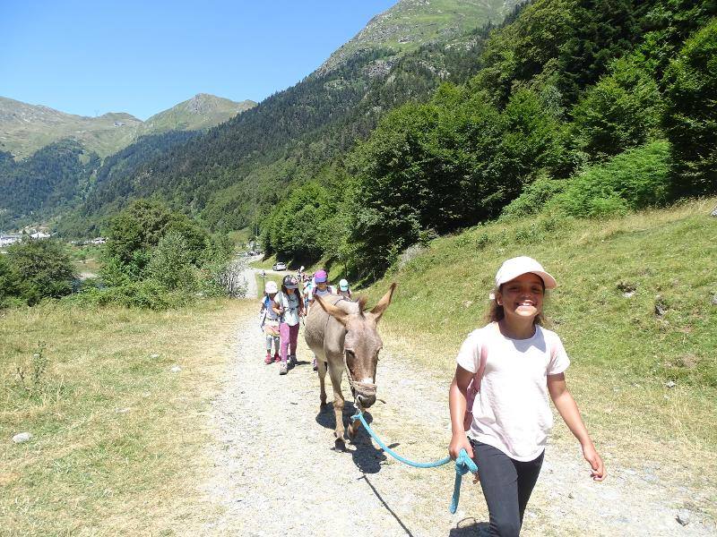 Les enfants de la colonie de vacance se balade dans les Pyrénées avec leur âne 
