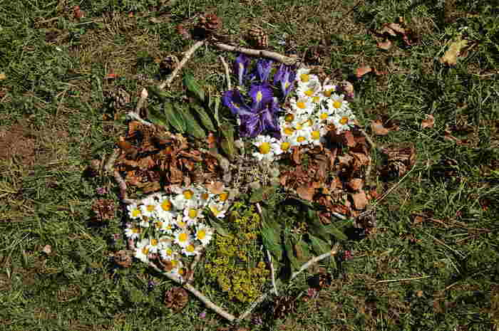 Collier de fleurs posé dans l'herbe  lors d'une colonie de vacances nature dans les Pyrénées