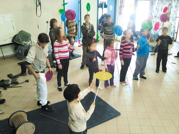 Des enfants font tourner des assiettes sur des bâtons pendant une colonie de vacances Pyrénées-Orientales