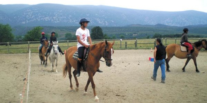 Des jeunes font de l'équitation avec leur professeur en colonie de vacances Pyrénées-Orientales