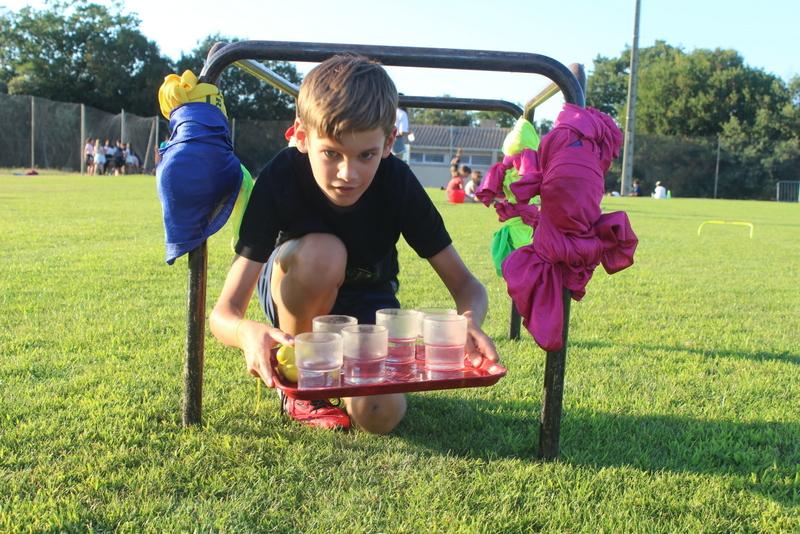 Enfant joue à un jeu d'adresse pendant une colonie de vacances Occitanie