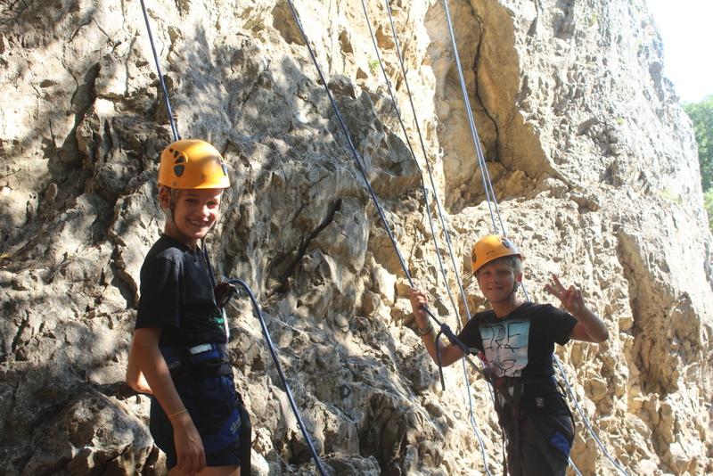 Deux enfants apprenant l'escalade pendant une colonie de vacances Occitanie