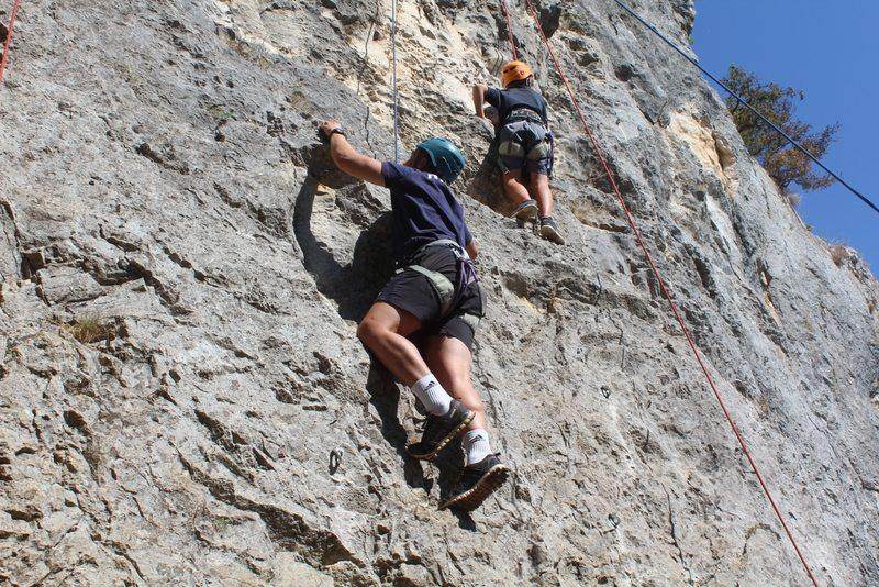 Deux enfants faisant de l'escalade pendant une colonie de vacances Occitanie