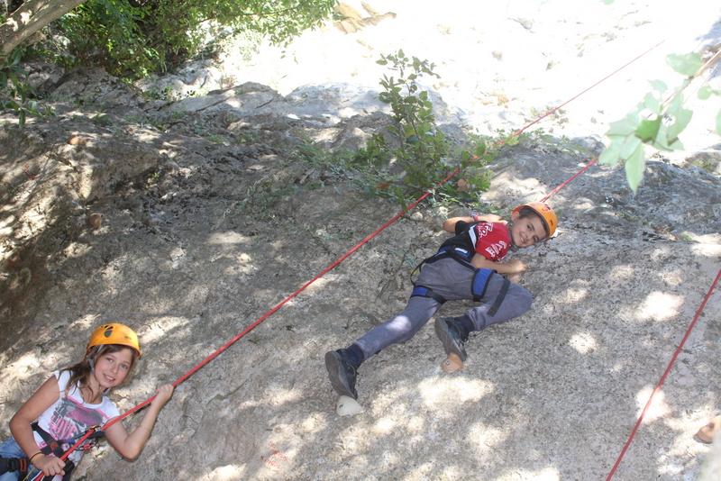 Deux enfants faisant de l'escalade pendant une colonie de vacances Occitanie