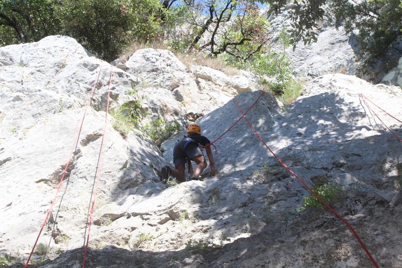 Un enfant faisant de l'escalade lors d'une colonie de vacances Occitanie