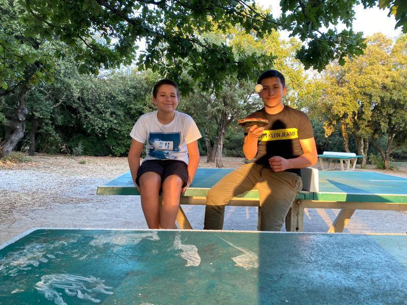 des ado assis sur une table de tennis en colonie de vacances occitanie 