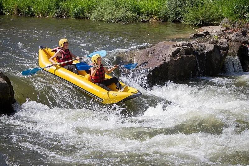 Deux jeunes descendent des rapides en canoë durant leur colonie de vacance