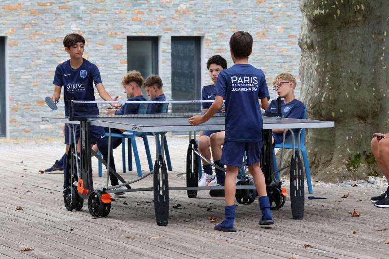 Des jeunes jouent au ping pong lors d'une colonie de vacances football
