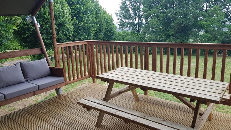 Terrasse en bois avec chaise à bascule et table de pique-nique à la colonie de vacance Tarn-et-Garonne
