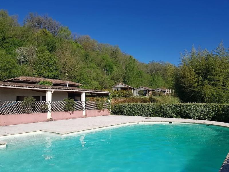 piscine avec une eau claire située en pleine nature sous un ciel bleu en été 