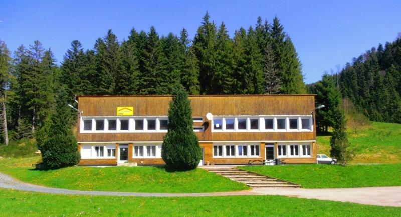 Vue frontale du centre de la colonie de vacances Vosges entre les arbres 