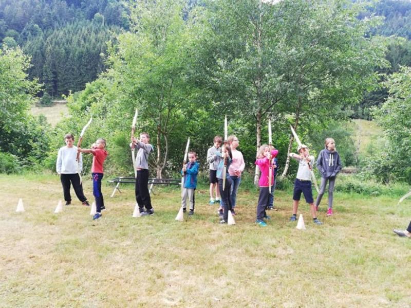 Des enfants tirent à l'arc en colonie de vacances Vosges