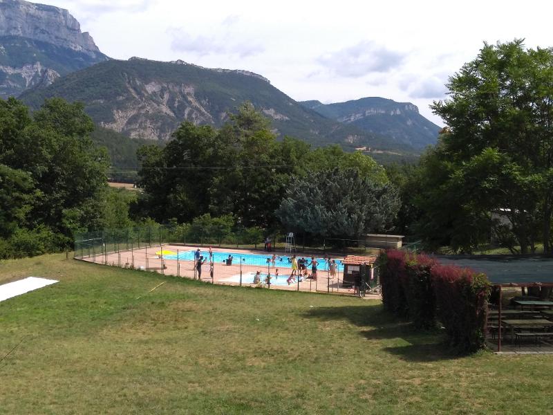 enfants qui s'amusent dans une piscine au pied des montagnes 
