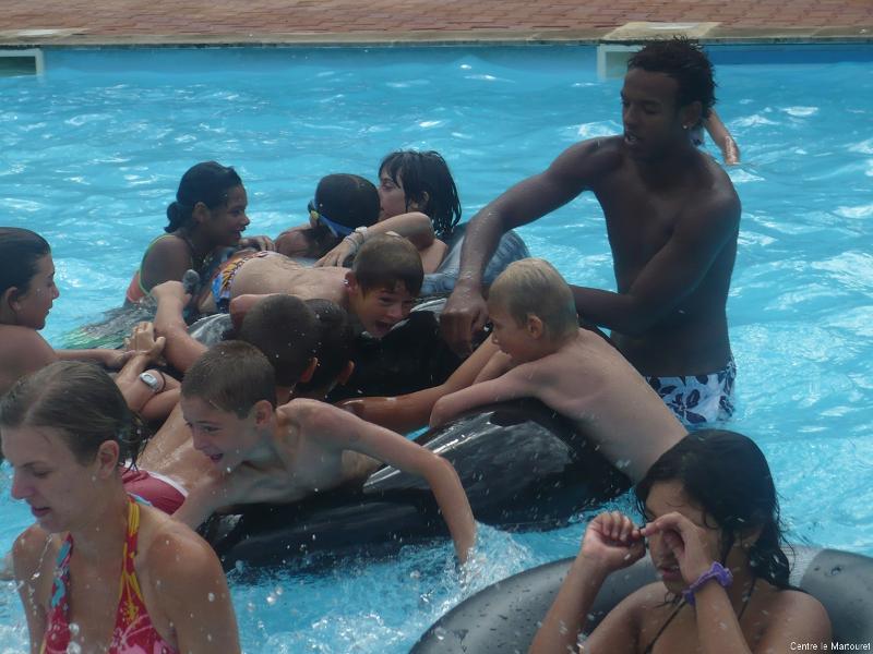 enfants s'amusent dans l'eau et animateur les surveille